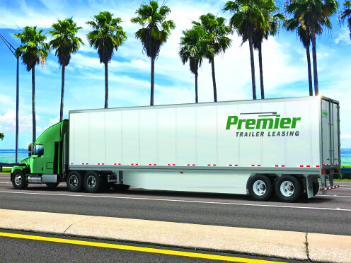 Premier truck driving with palm trees on the side of the road